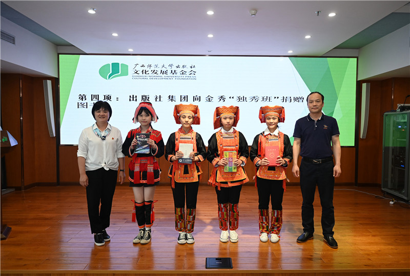 廣西師范大學(xué)出版社集團副總裁、工會主席莫曲波（右一）代表出版社向金秀“獨秀班”同學(xué)贈送圖書（李顯楊攝）.jpg
