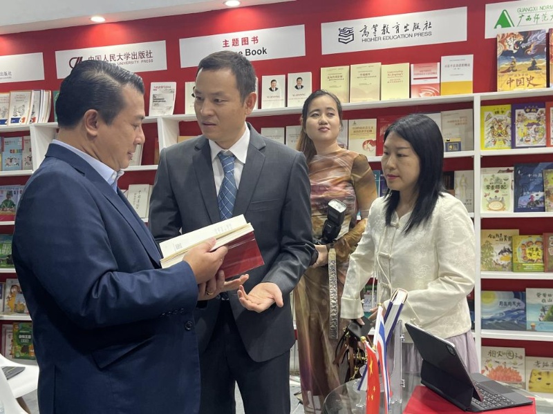 泰國書商和出版商協(xié)會主席蘇維奇（左一）在翻閱《近鏡頭：溫暖的瞬間》。（盧雯 攝）jpg_副本.jpg